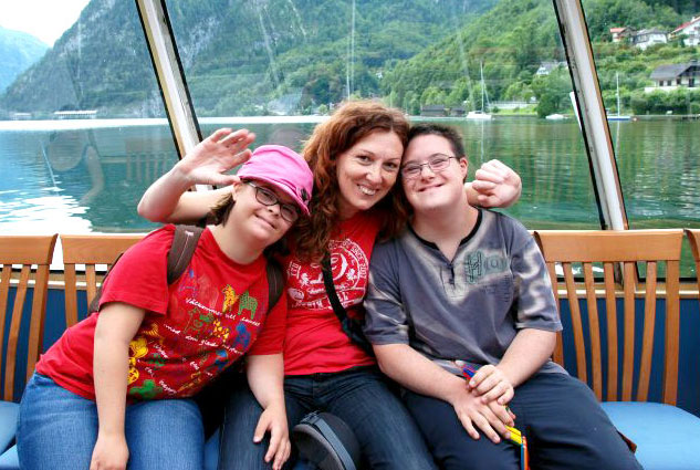 Betreuerin mit zwei Kindern mit Downsyndrom am See